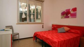 Quarto com cama, escrivaninha e cadeira.