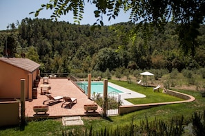 A patio with outdoor furniture, a swimming pool, and a view of a forested hillside. - Mulino Della Rivolta (Collesalvetti)