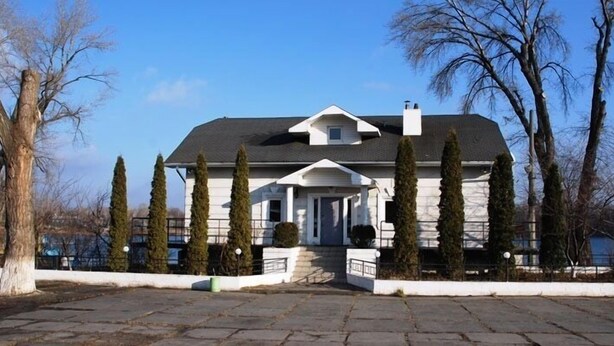 A two-story house with a symmetrical facade, a central entrance, and a covered porch.