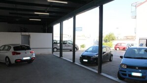 Un área de estacionamiento techada con varios coches aparcados.