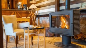 Una habitación acogedora con una estufa de leña, asientos cómodos y una decoración rústica.