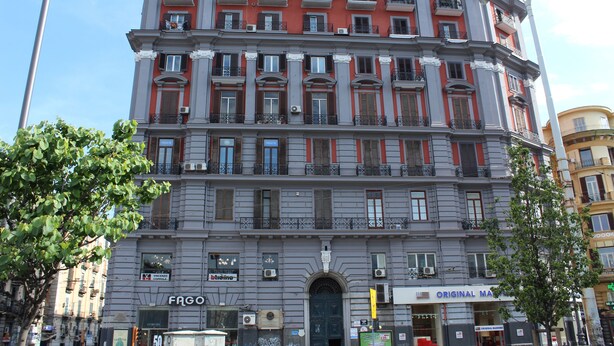 A multi-story building with a classic architectural style, featuring a central entrance with a decorative archway. - N'Art Suites Napoli (Naples)
