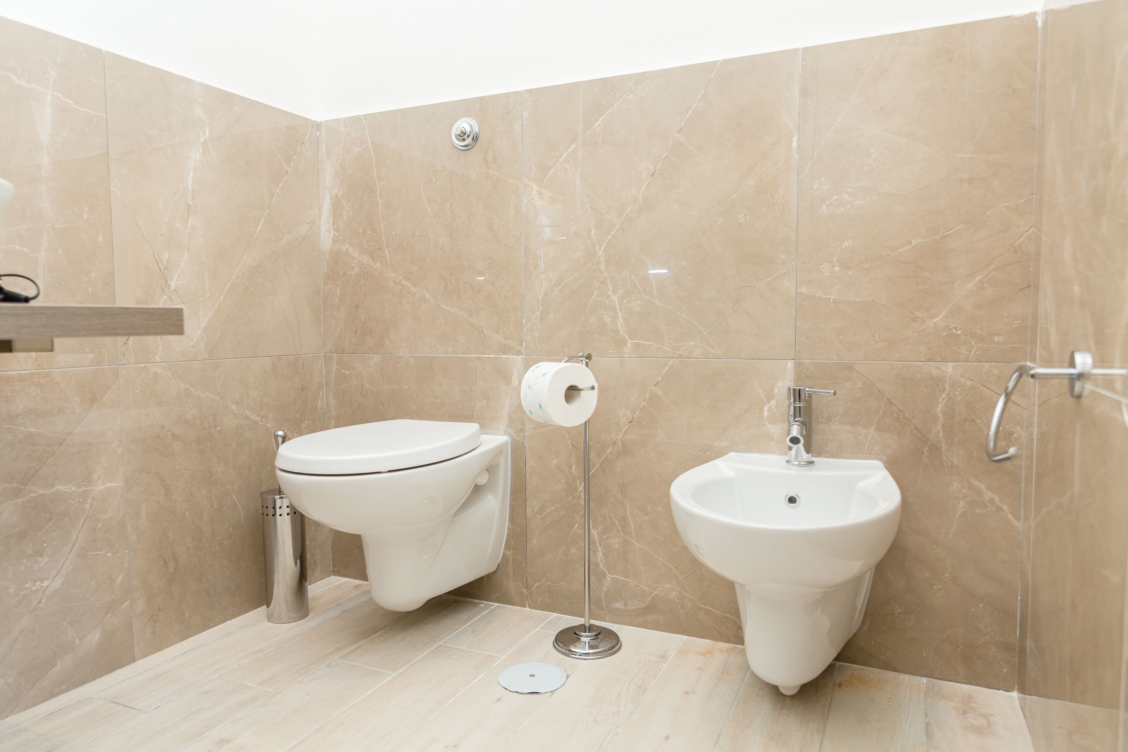 A modern bathroom with a toilet, bidet, and a sink.