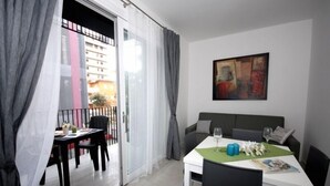 A modern apartment with a balcony, a dining area, and a living room. - Arketipi (Lignano Sabbiadoro)