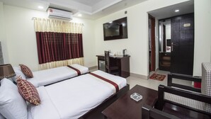 A hotel room with two beds, a desk, a chair, a television, and an air conditioning unit. - Hotel Ali Plaza (Sylhet)