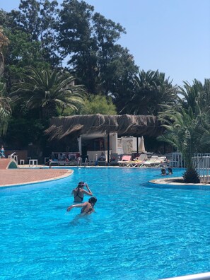 季节性开放的室外游泳池，池畔遮阳伞，日光浴躺椅