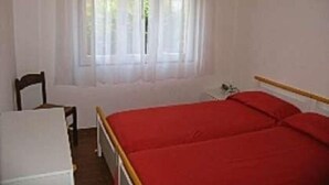 Una habitación con una cama, una silla y una pequeña mesa.