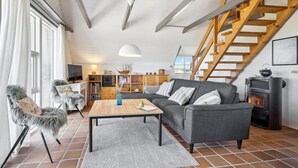 Un salon chaleureux avec un canapé, une table basse en bois et une cheminée.