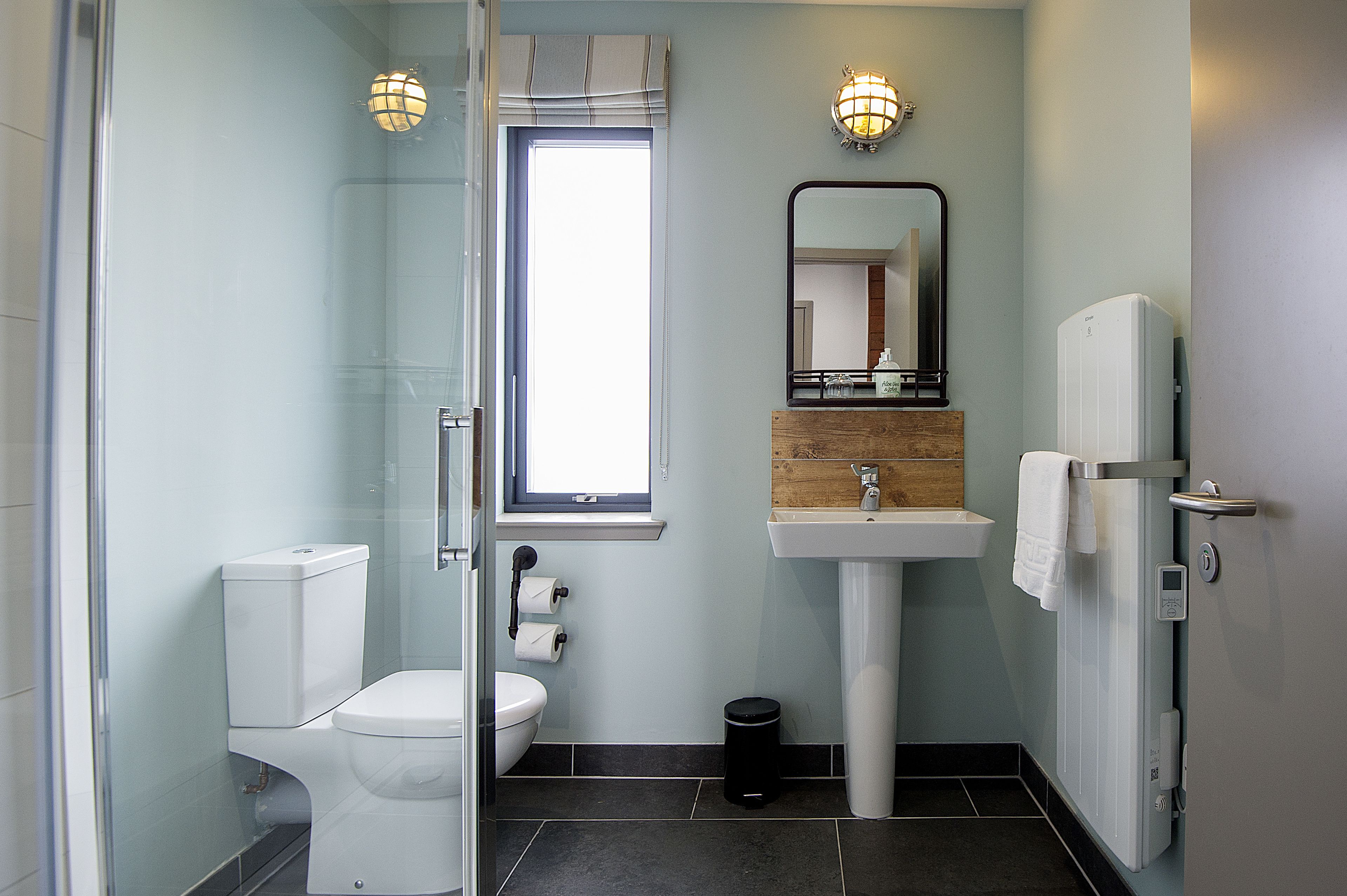 Une salle de bain moderne équipée de toilettes, d’un lavabo et d’une douche.