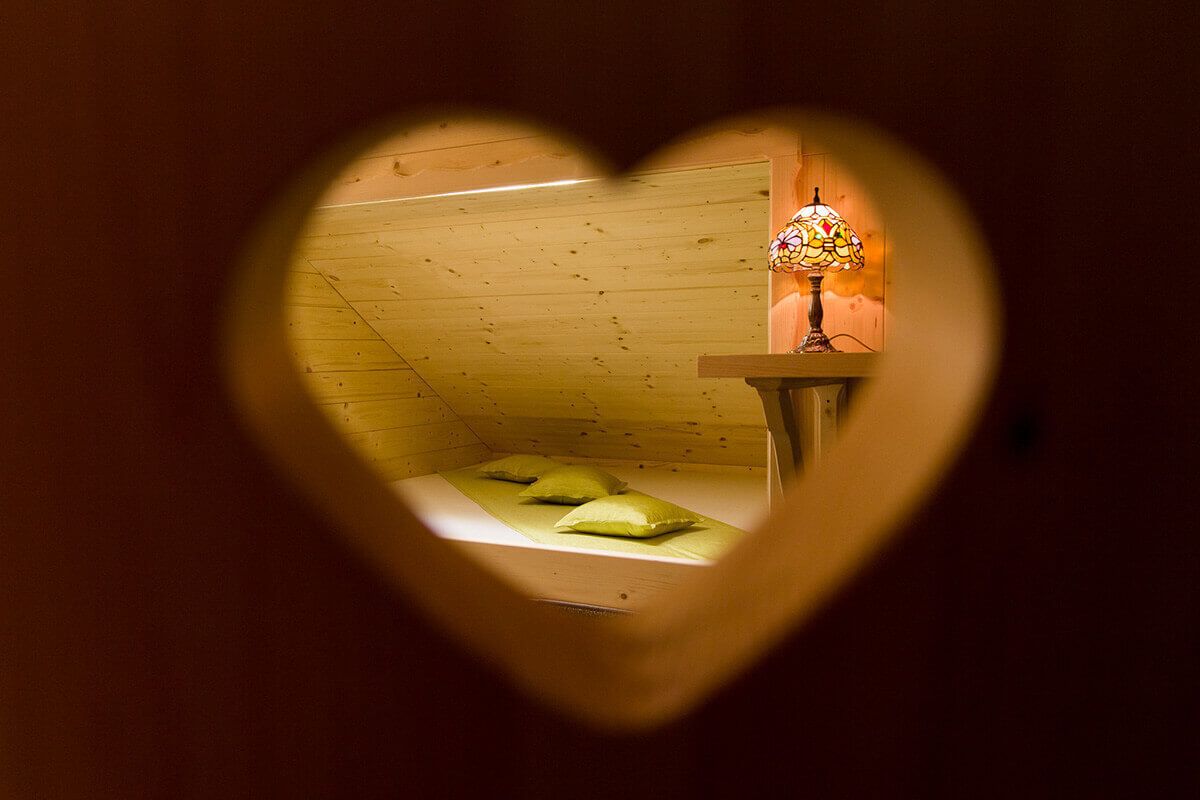 A room with a wooden ceiling and a bed with pillows.