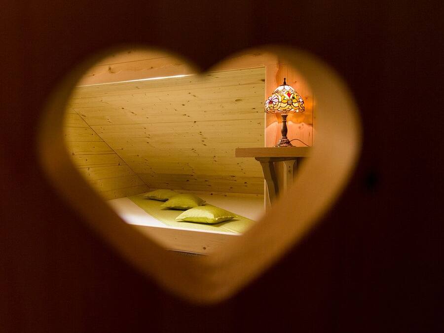 A room with a wooden ceiling and a bed with pillows.