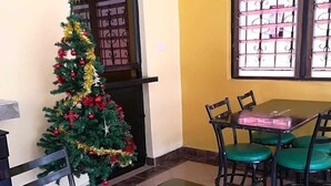 A room with a Christmas tree, a table with chairs, and a sign reading "CASHIER".