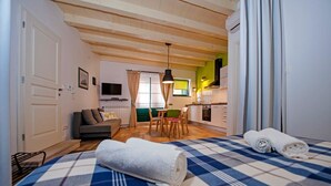 A cozy room with a bed, a sofa, a dining table, and a kitchen area. - Apartment Luxury Rovinj (Rovinj)