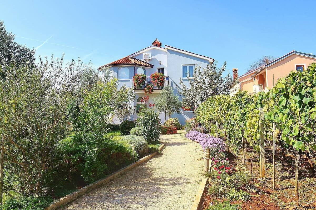 A two-story house with a garden path leading to the entrance.