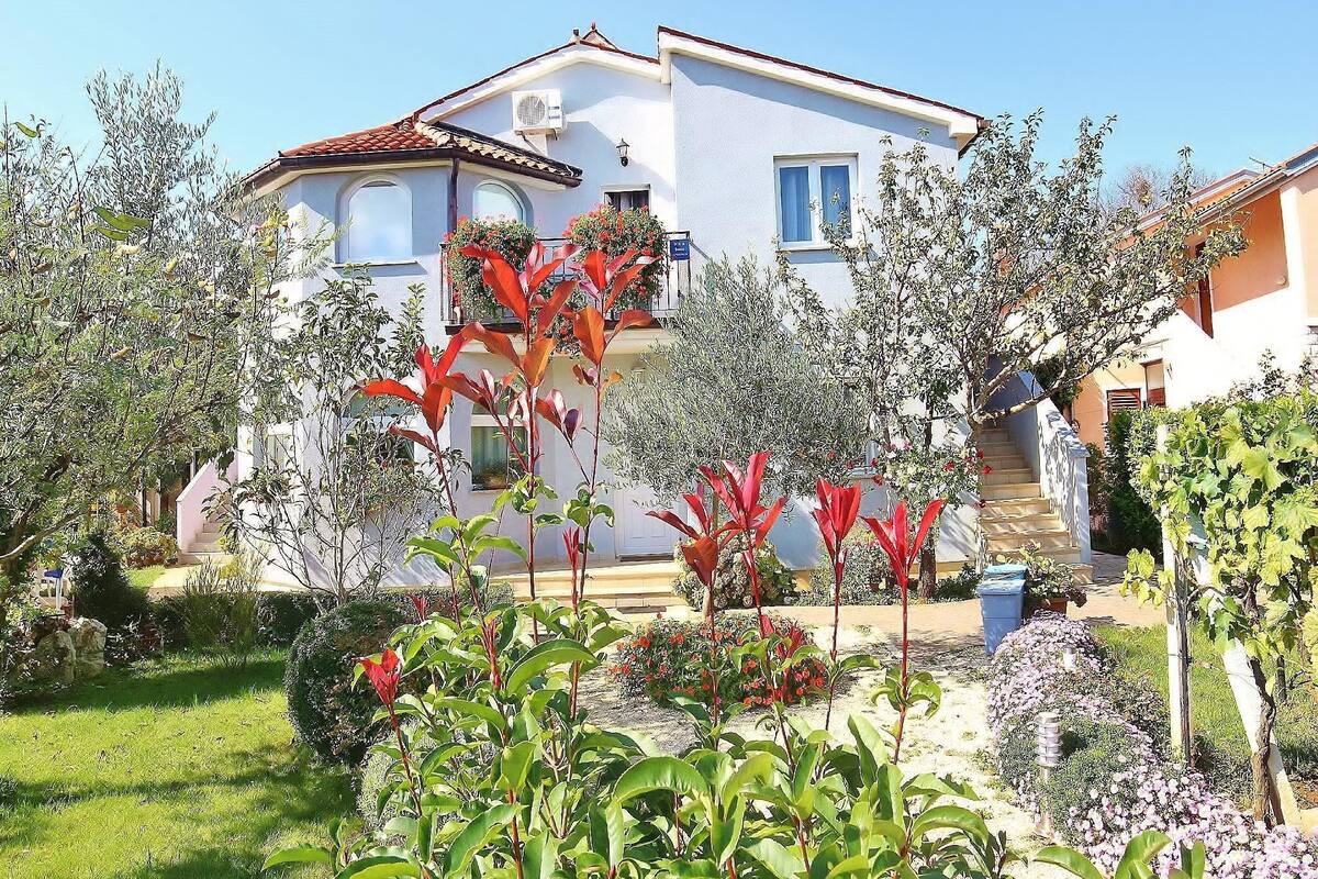 A two-story house with a garden in front.
