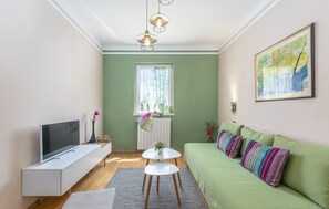 Apartamento, 1 cama King | Área de estar | TV 65 cm com canais via satélite, DVD player