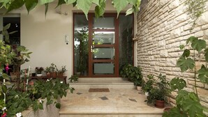 A stone wall, a wooden door, and potted plants. - Apartments Levan Ceja (Medulin)