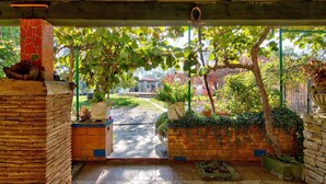 Un jardin aménagé et abrité, avec des murs en briques, des plantes en pot et un sol carrelé.