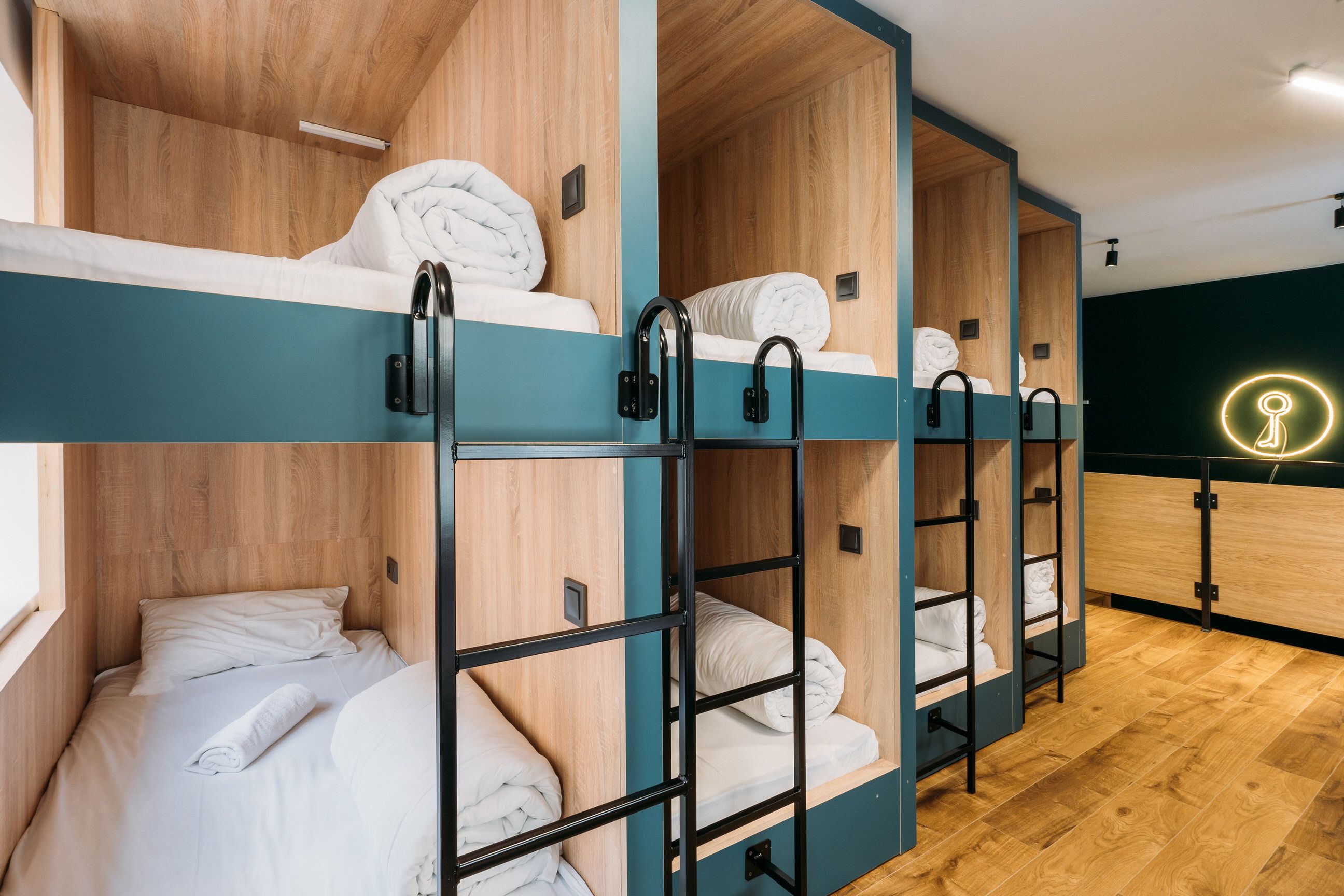 Une chambre avec un lit superposé, des murs en bois et des barrières de couleur turquoise.