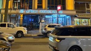 A hotel with a prominent entrance, multiple flags, and a sign indicating it is a hotel.