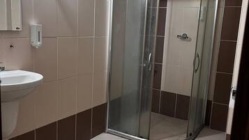 Habitació doble o amb dos llits individuals familiar | Bany | Dutxa, sabatilles i tovalloles