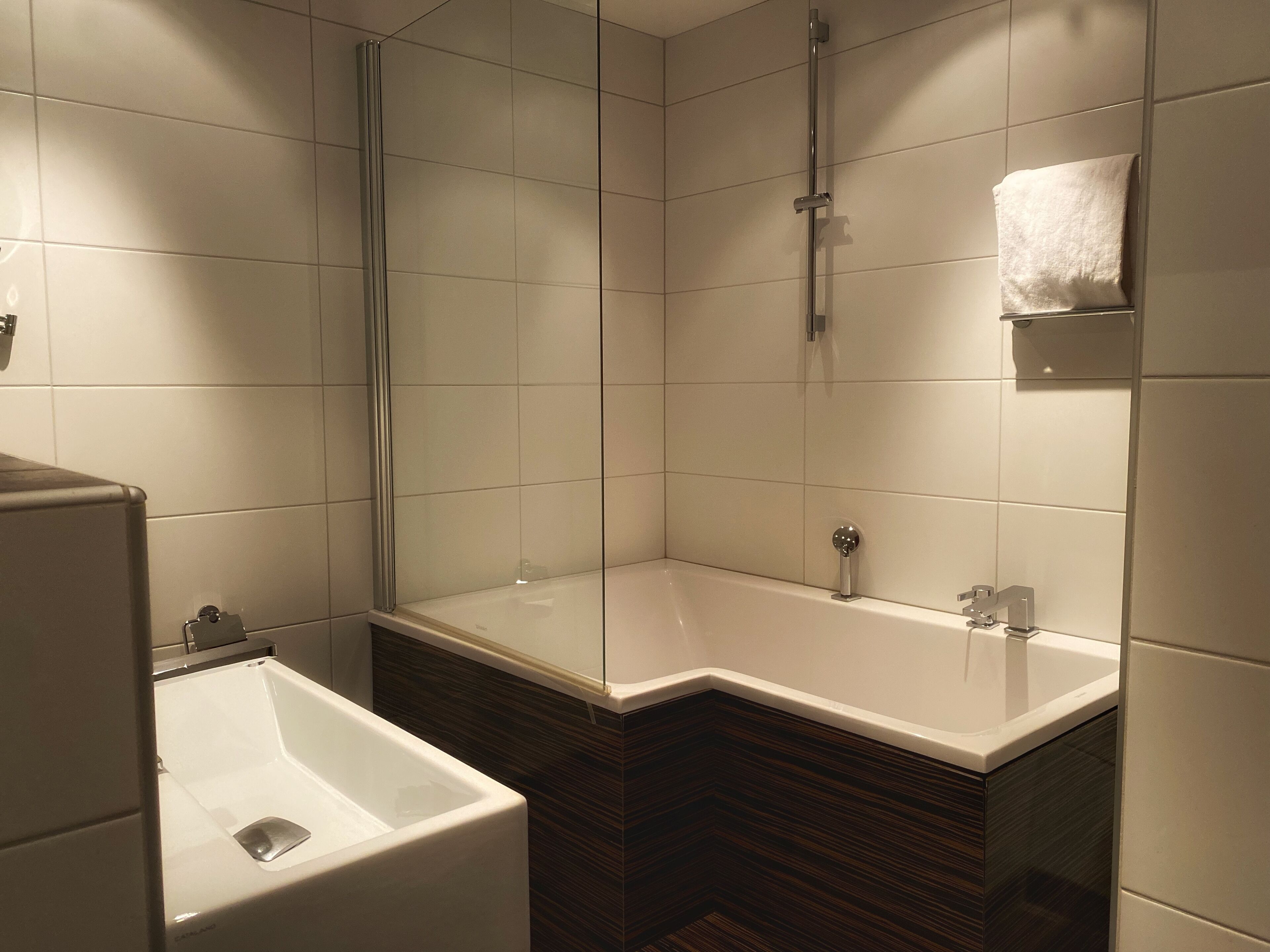 A modern bathroom with a shower, a bathtub, and a toilet.