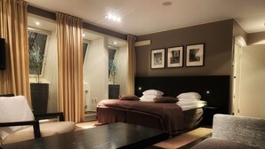 Une chambre moderne avec un grand lit, un bureau et un canapé.
