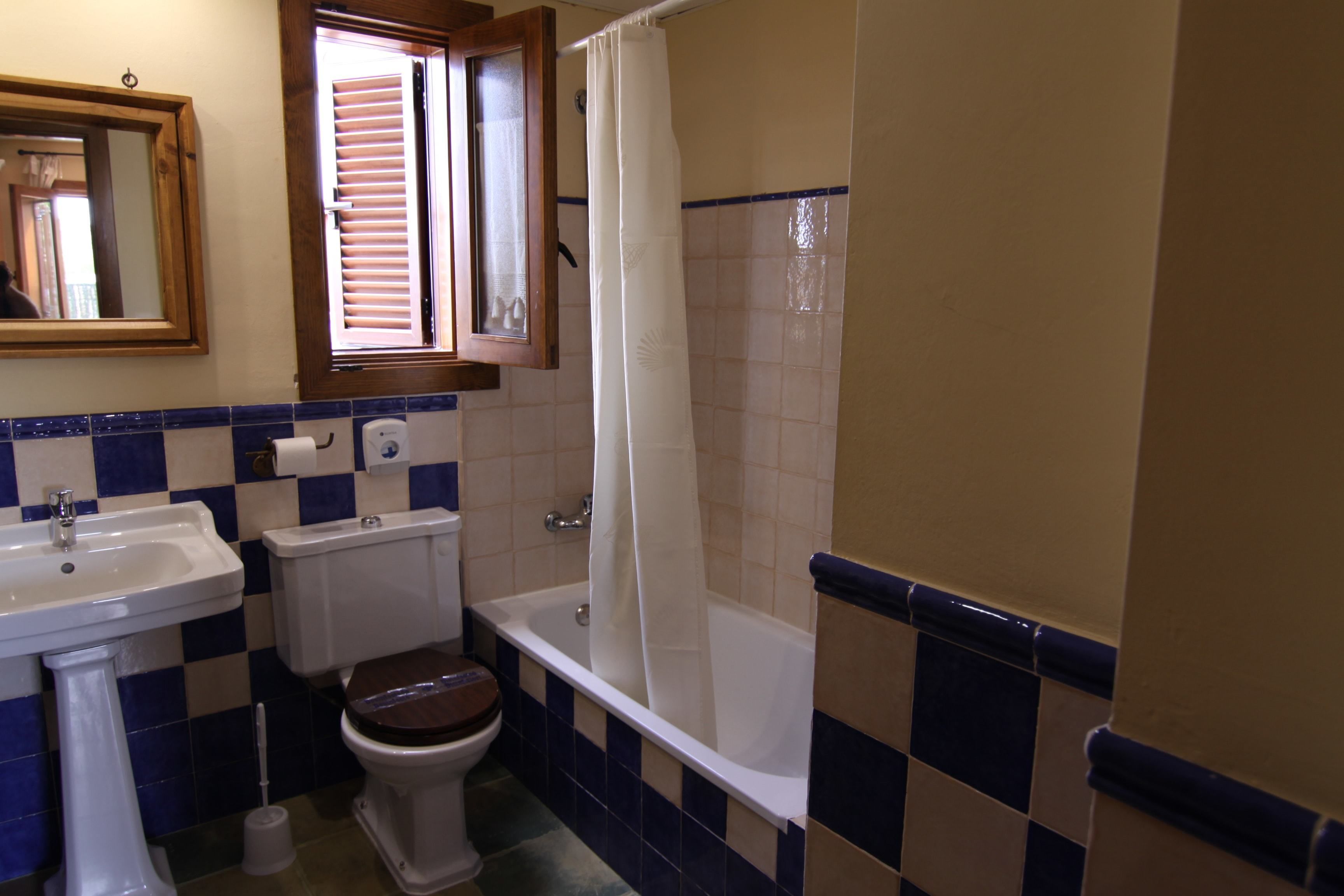 Et badeværelse med vask, toilet og badekar.