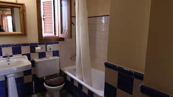 Et badeværelse med vask, toilet og badekar.