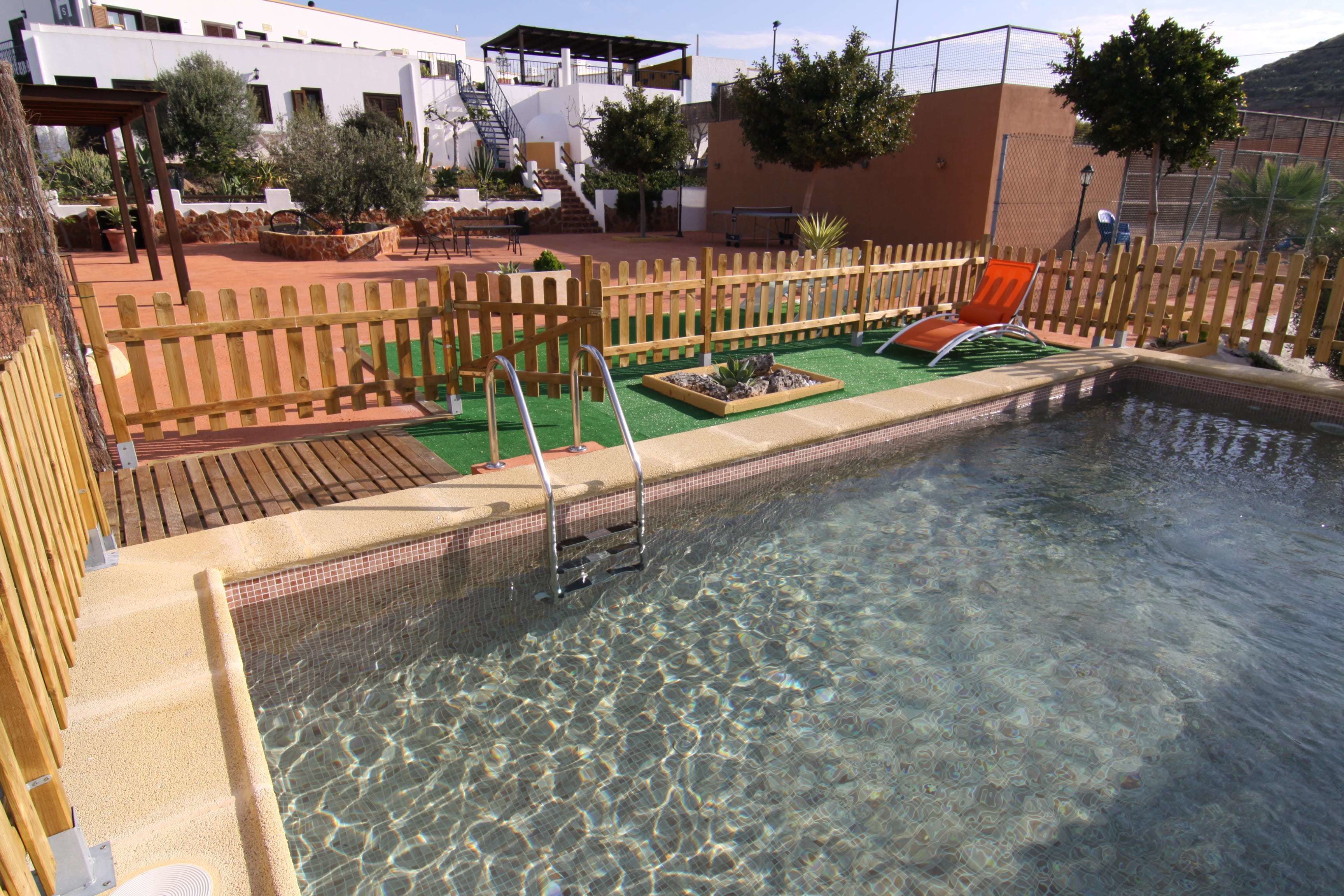 Een buitenzwembad en ligstoelen