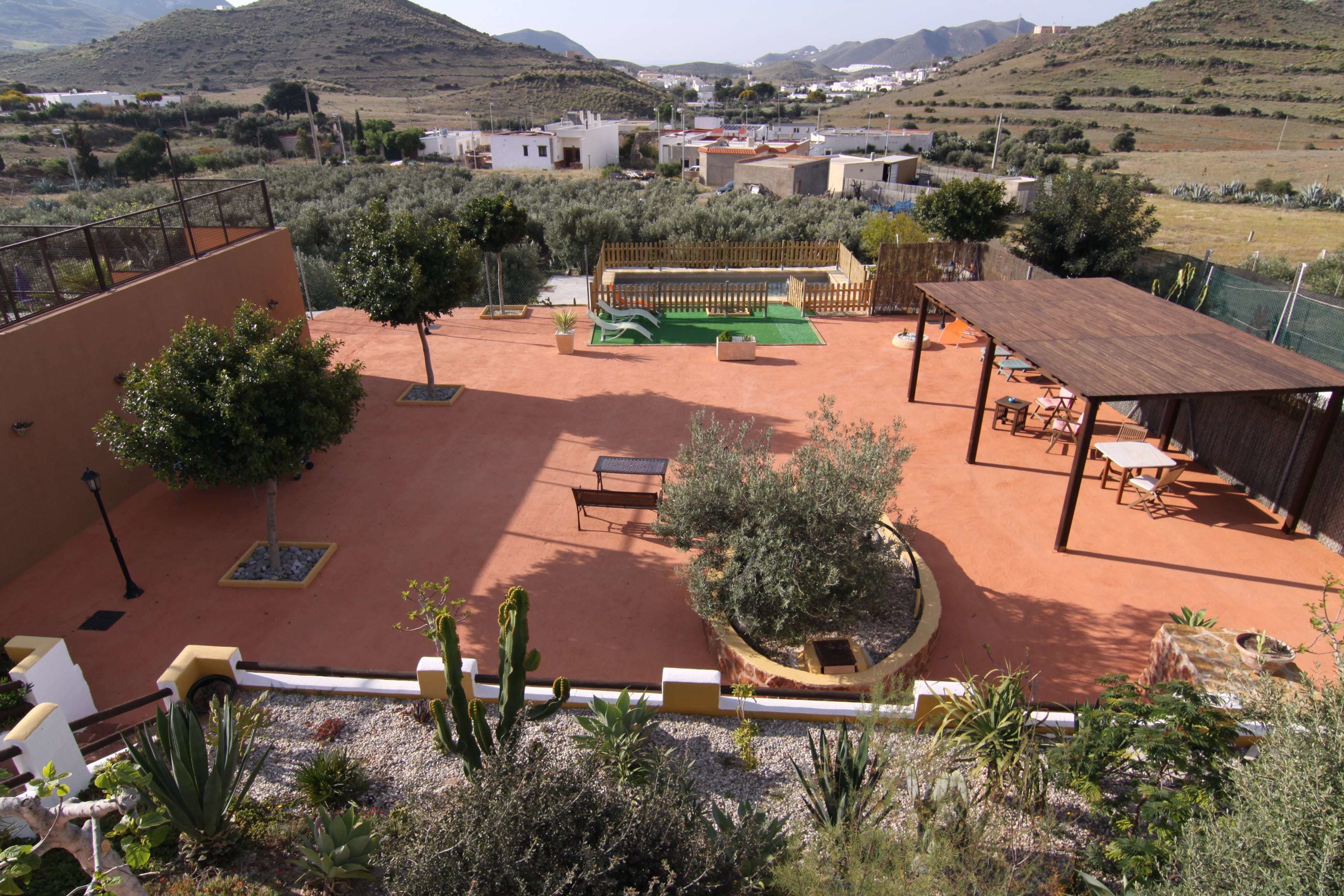 A courtyard with a wooden deck, seating area, and a small garden.