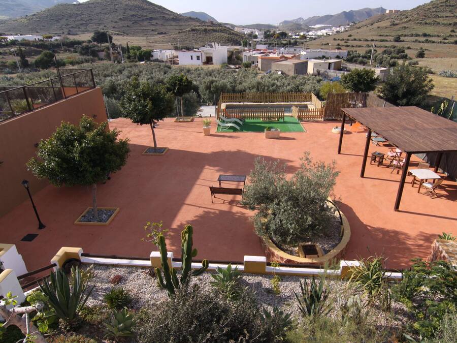A courtyard with a wooden deck, seating area, and a small garden.