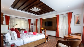 A hotel room with a bed, a desk, a chair, a TV, and a window with curtains. - Meraki Wellness Retreat (Burhanilkantha)