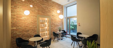 A modern interior with brick walls, round tables, and black chairs.