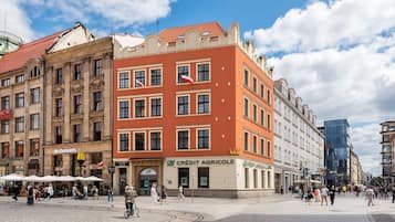 A historic building with a red facade, a McDonald's, and a 'CREDIT AGRICOLE' sign.