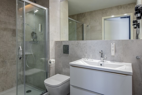 A modern bathroom with a glass-enclosed shower, a white sink, and a toilet. - Korona Hotel Wroclaw Market Square (Wroclaw)