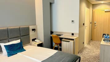 Una habitación de hotel con cama, escritorio, silla y armario.