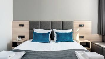 Een moderne hotelkamer met een groot bed, twee nachtkastjes en een hoofdbord.