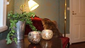 A table with two decorative glass candle holders and a potted plant. - Divine Living - Apartments (Stockholm)