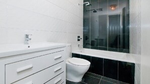 A modern bathroom with a white vanity, a toilet, and a glass-enclosed shower. - Home for rent asap now is available to move in (Austin)