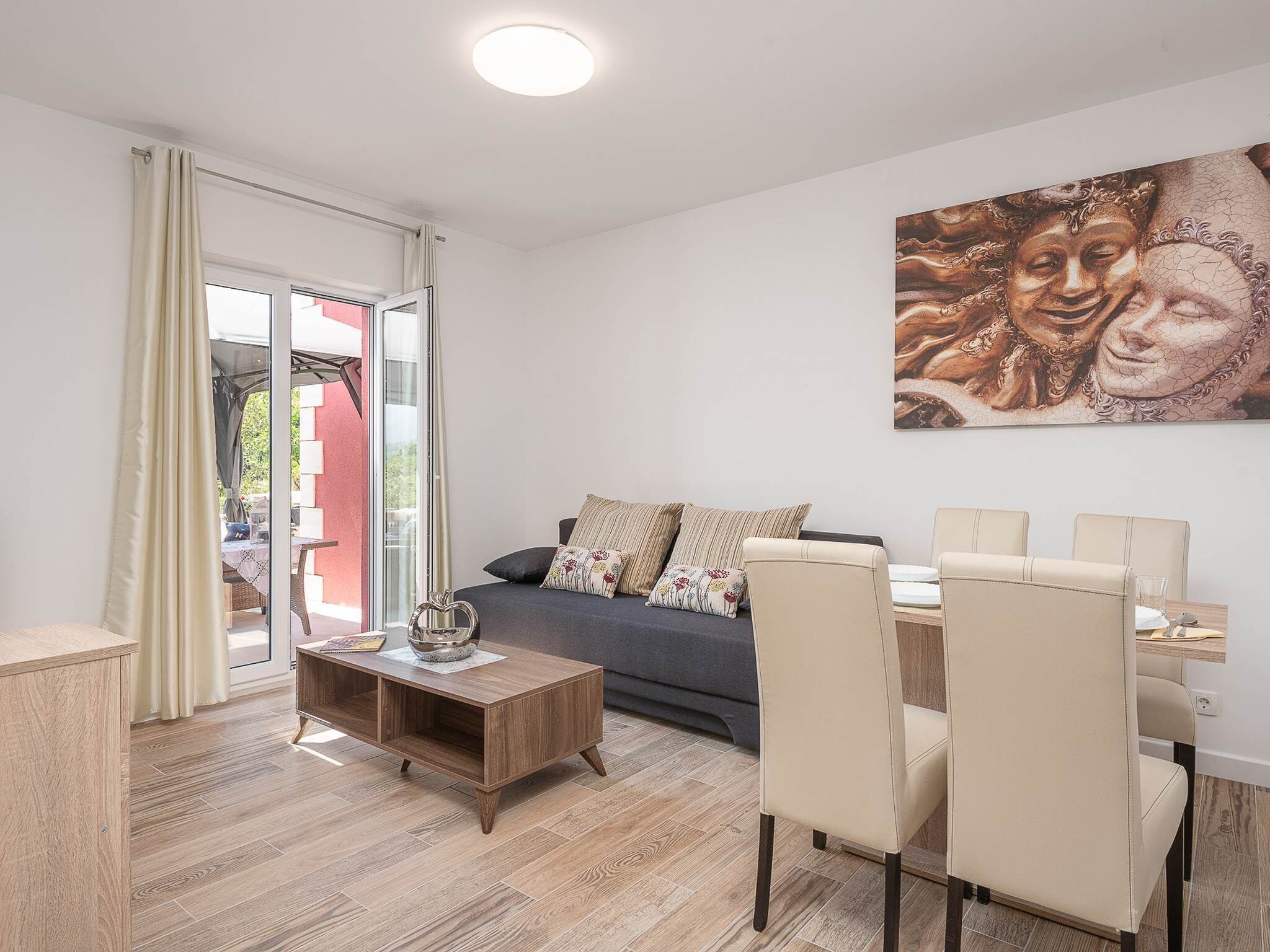 Uma sala de estar moderna com sofá, mesa de centro e área de jantar.