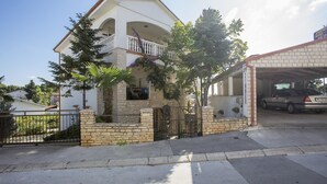 A two-story house with a balcony, a garage, and a driveway. - Apartments Jakša (Pula)