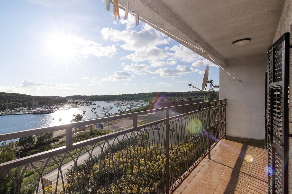Un balcon donnant sur une marina et sur une étendue d’eau.
