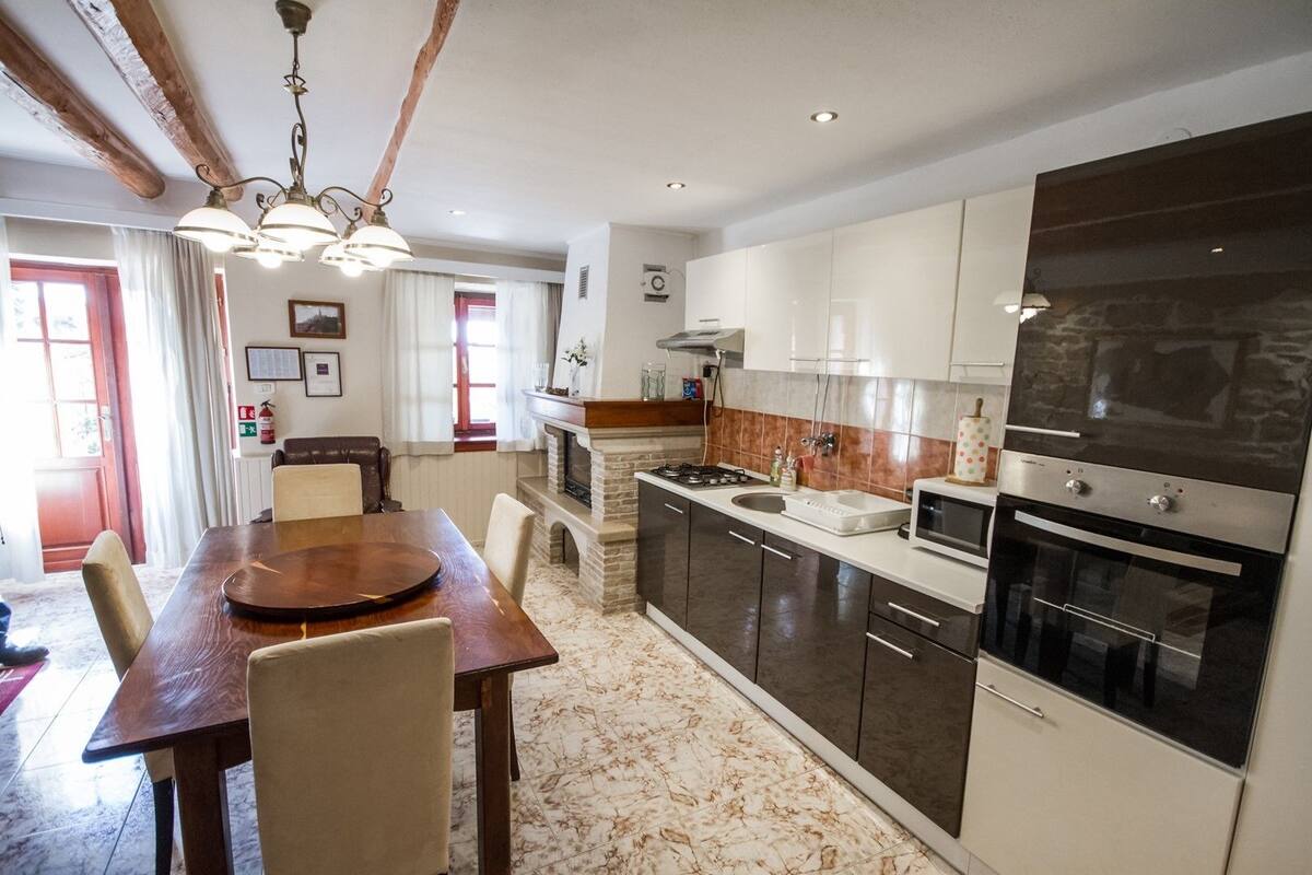 A modern kitchen with dark cabinets, a built-in oven, and a microwave.