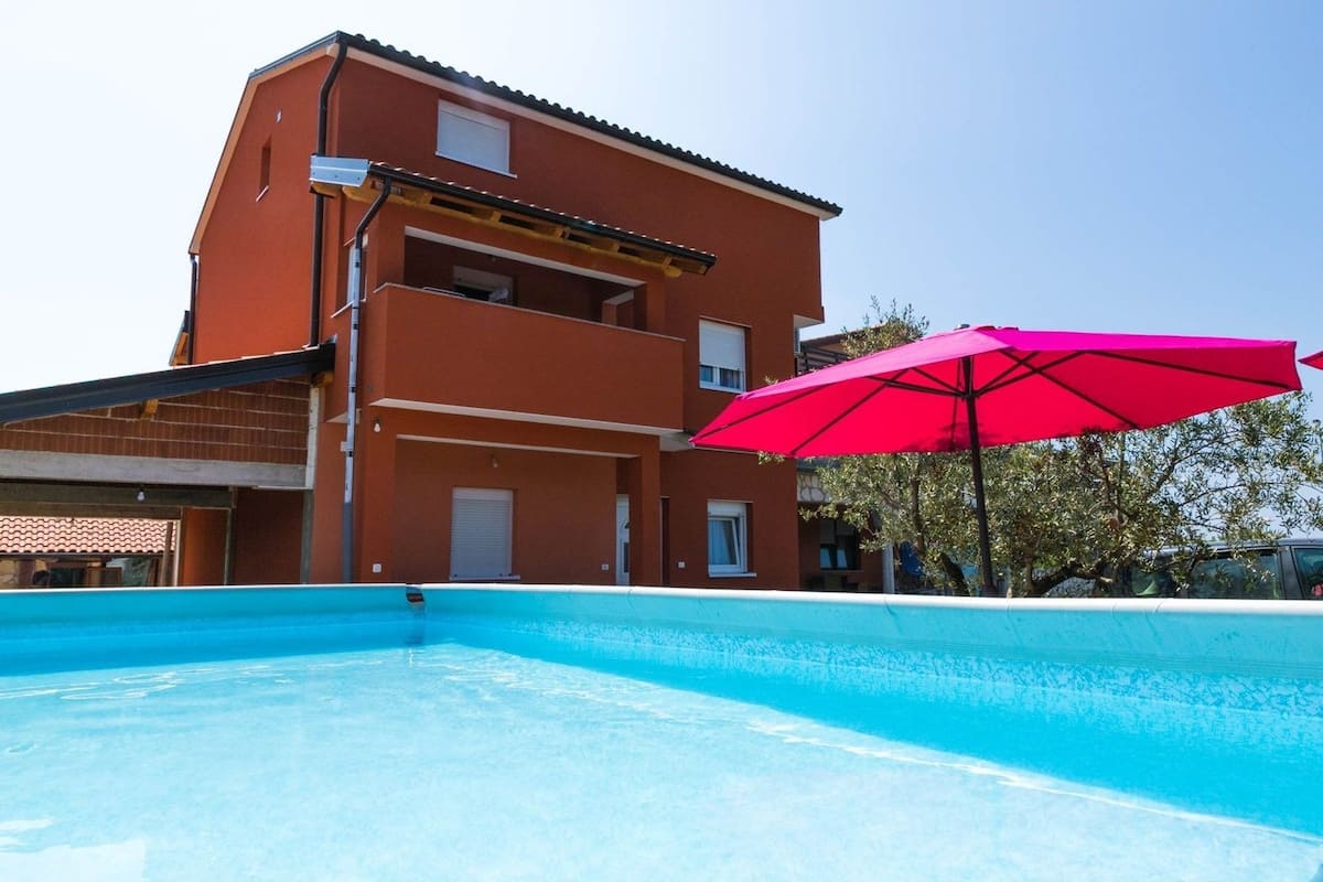 Um edifício de dois andares com piscina em frente.