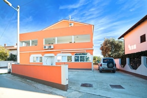 A two-story building with a flat roof, large windows, and air conditioning units. - Apartments Orange Medulin (Medulin)