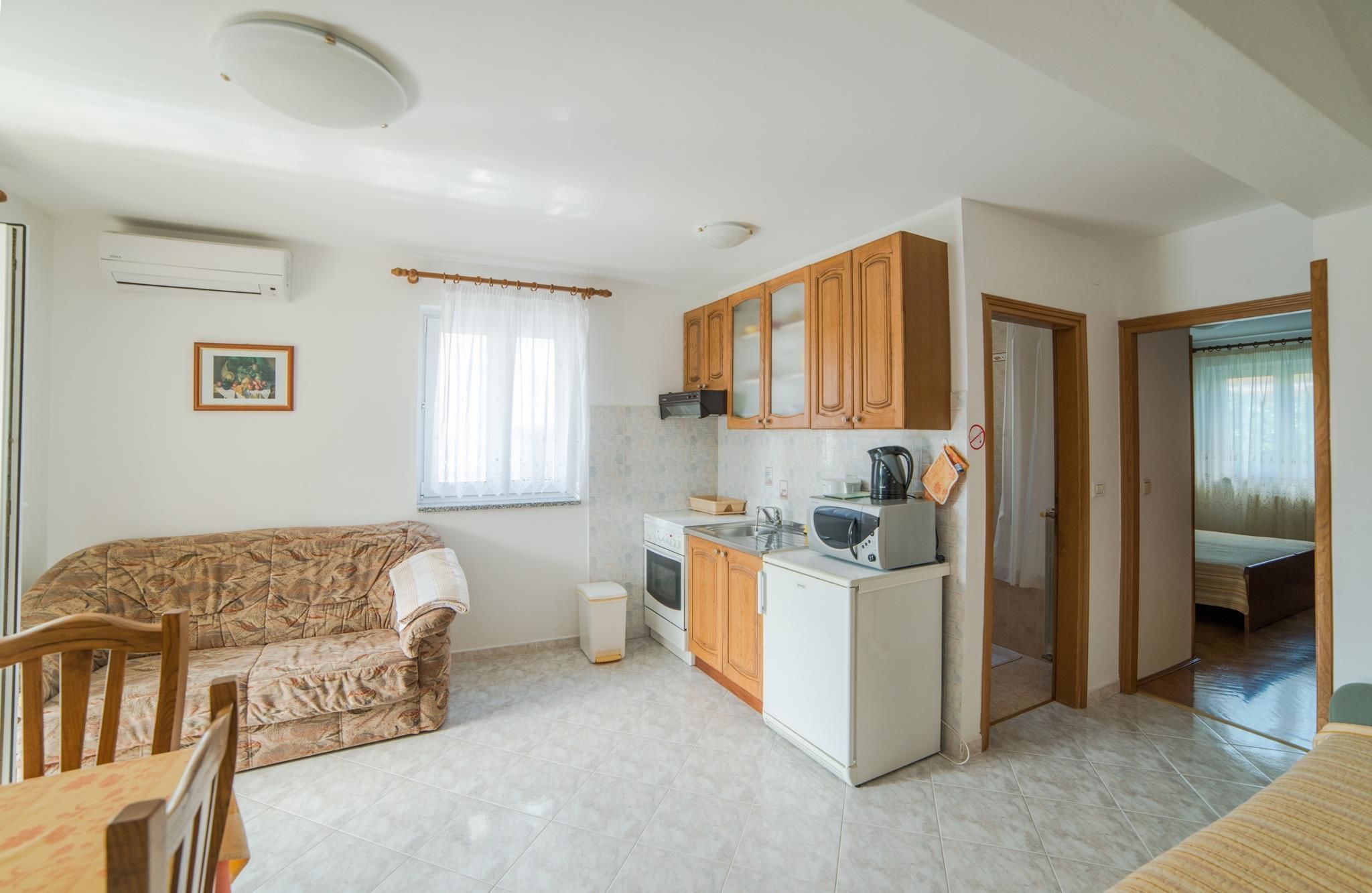 A compact living space with a kitchenette, a sofa, and a dining area.