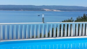 A swimming pool with a view of a calm body of water and distant mountains. - Apartments Vesna Mimice (Omis)