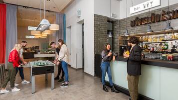 A bar area with a foosball table, a buffet sign, and a bar sign.