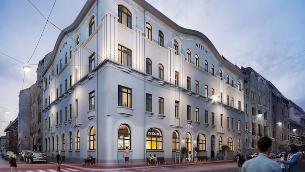 A multi-story building with arched windows and a prominent 'a&o' sign on the ground floor. - a&o Budapest City - Hostel (Budapest)